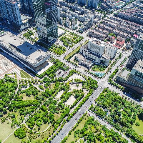 Vue aérienne d'une ville chinoise avec des gratte-ciel et des parcs verdoyants.