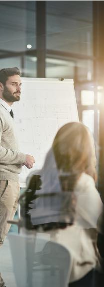 Homme présentant un projet sur un tableau blanc, gestion de projet AMO