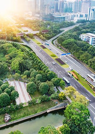 Vue aérienne d'une autoroute bordée d'arbres, paysage urbain moderne